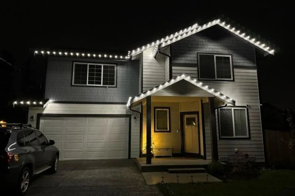 MCA Christmas lighting installation on a home at dusk